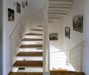 Staircase inside the first Passive House with various paintings on the wall