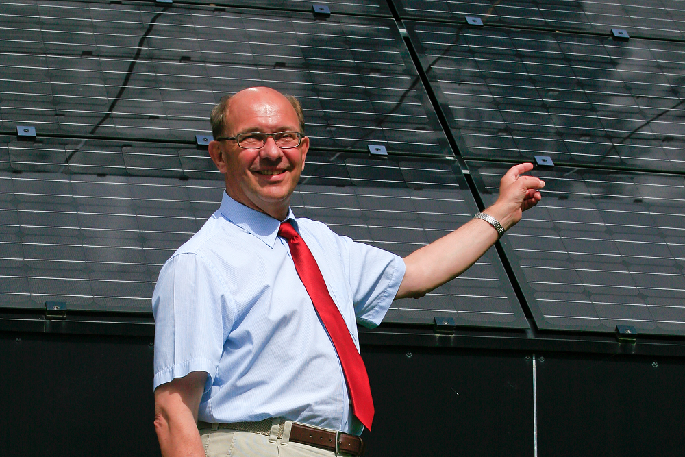 Headshot of a Mr. Torben Esbensen standing in front of an array of solar panels