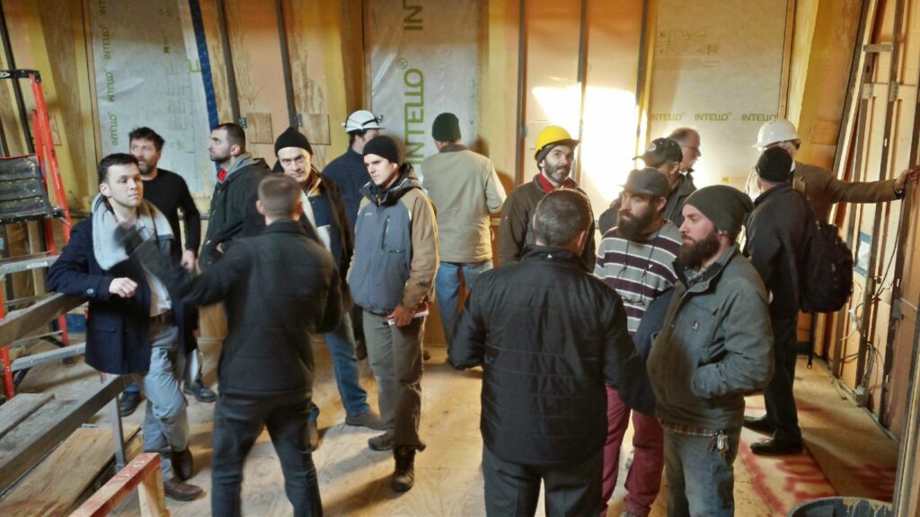 Builders, architects, clients, and other interested parties chatting at a Passive House construction site