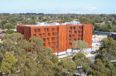 View of the entire Monas Gillies Hall Passive House Project. Distinguishable by its bright orange color.