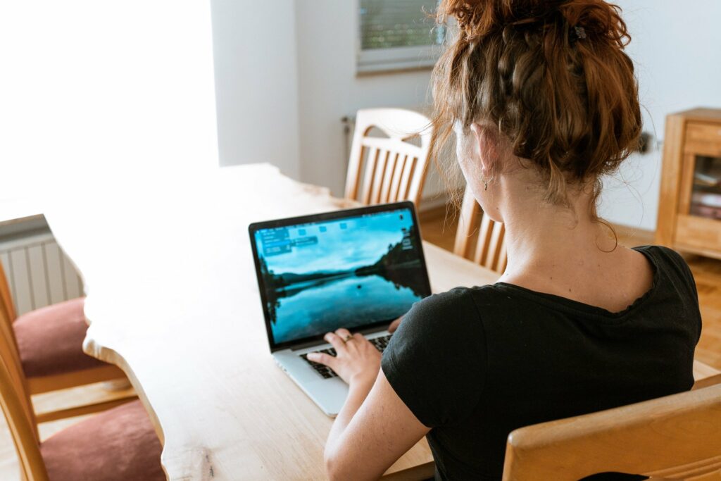 Women sitting at kitchen table on laptop. 